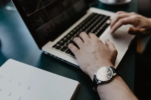 男性用笔记本电脑和一杯咖啡工作