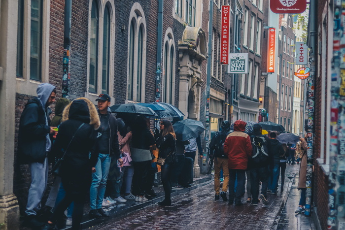 一群人撑着雨伞走在人行道上