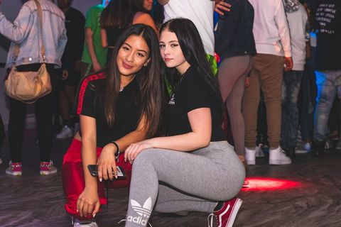 两个女人面带微笑，几乎坐在人群中