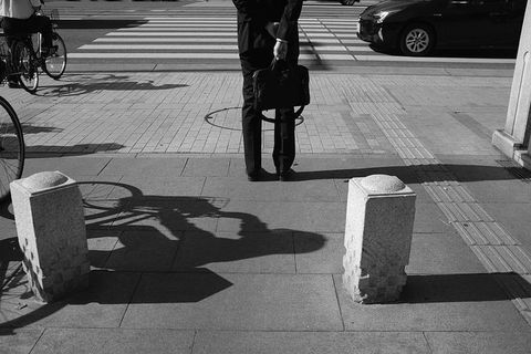 两个灰色的柱子，沥青，柏油路面，行人，人，人，机器，*