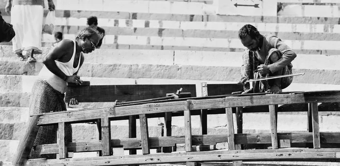 拿着木头的人，人，人，衣服，衣服，木头，短裤，建筑