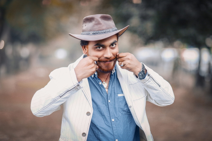 一名男子身穿白色上衣，双手放在脸颊上