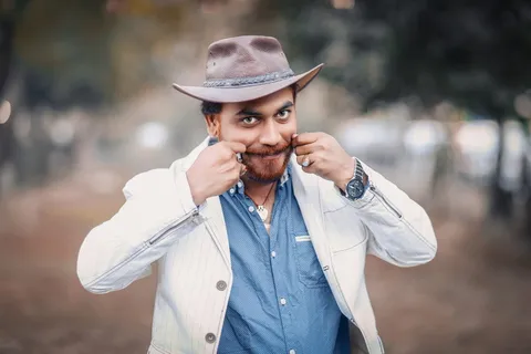 一名男子身穿白色上衣，双手放在脸颊上