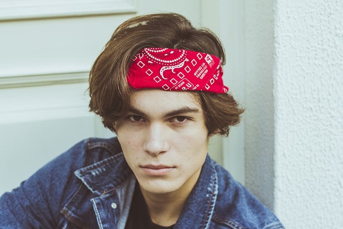 身穿蓝色牛仔夹克和红色大手帕的男子