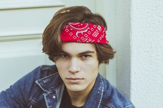 身穿蓝色牛仔夹克和红色大手帕的男子