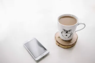 黑白笔记本和带有各种物品的白色智能手机