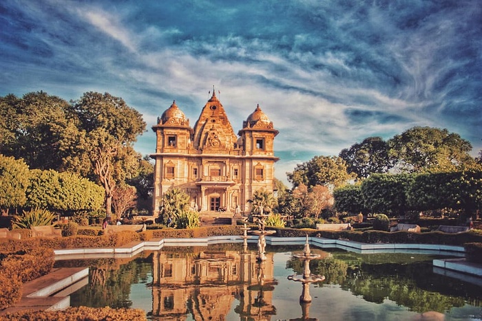 蓝色和灰色天空下喷泉附近的棕色混凝土建筑