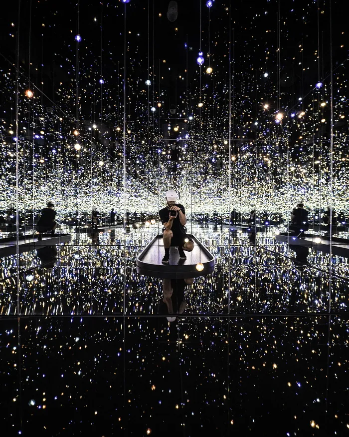 被灯光包围时，一名男子在镜子上拍照