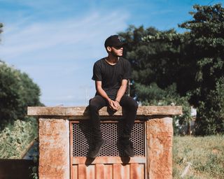 坐在混凝土路面上侧视的男子