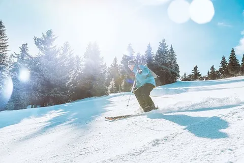 滑雪者在晴朗的日子里在高山上滑下山