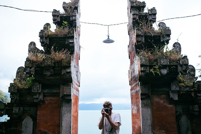 一位旅行者摄影师在寺庙入口处点击照片