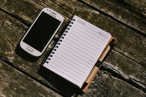 木质背景上有各种物品的白色智能手机