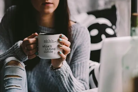 在杯子里喝酒的女孩