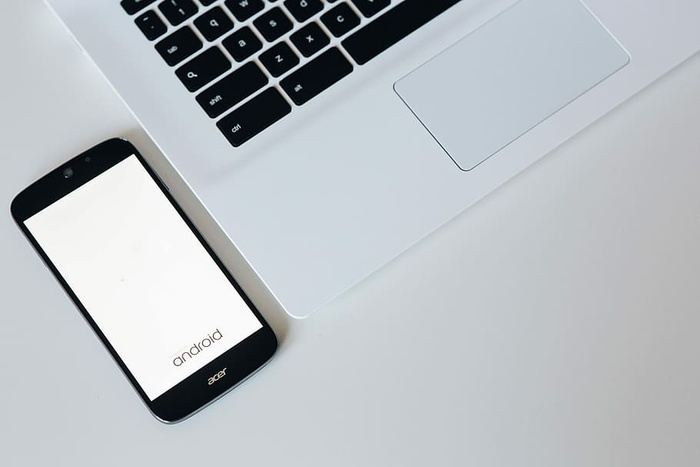 带智能手机和耳机的白色笔记本电脑