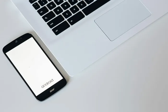 带智能手机和耳机的白色笔记本电脑