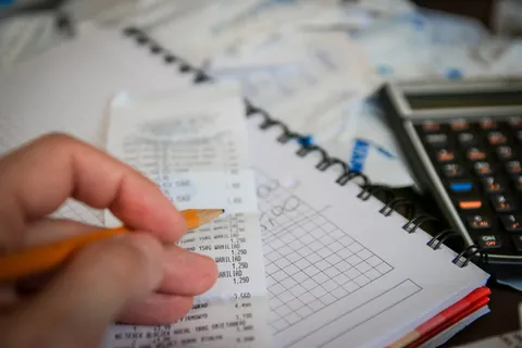 人、手、铅笔、收据纸、钱、账单、计算器、储蓄 人、手、铅笔、收据纸、钱、账单、计算器、储蓄
