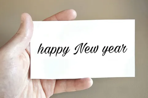 手里拿着一张写着新年快乐的卡片——白卡 手里拿着一张写着新年快乐的卡片——白卡
