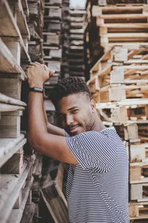 站在木托盘旁的男子 站在木托盘旁的男子