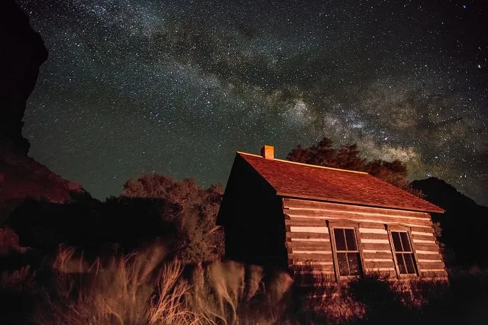 犹他州国家公园的一栋房子，在夜空和星星的映衬下