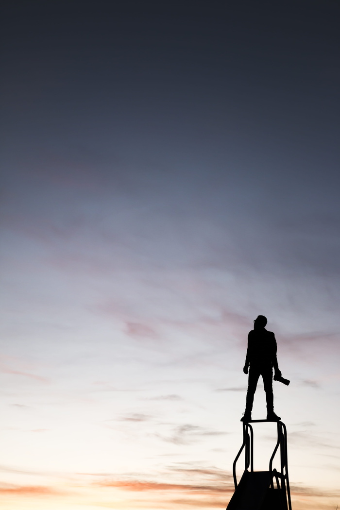 男子手持摄像机站在滑梯上的剪影