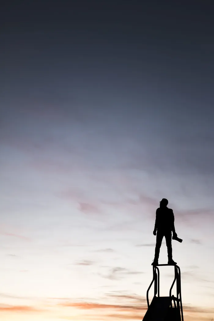 男子手持摄像机站在滑梯上的剪影