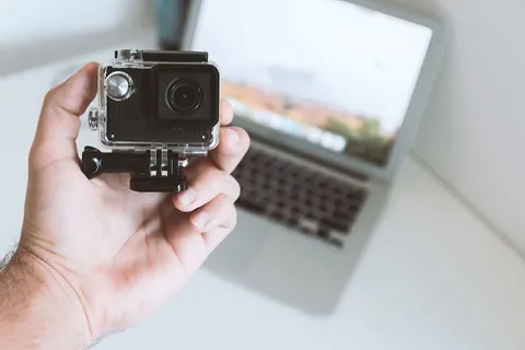 办公室工作人员手中的现代小型运动和户外相机