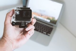 办公室工作人员手中的现代小型运动和户外相机