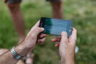 男子手在手机上玩电子游戏的特写镜头