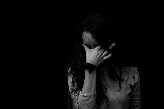 女性触摸眼睛的灰度照片