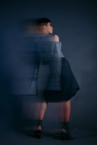 身穿蓝色长袖上衣和黑色裙子的女士