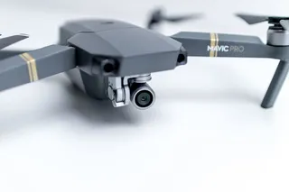 办公室白色办公桌上的现代无人机准备拍摄