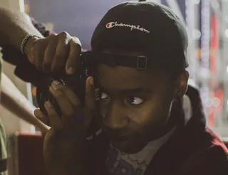 戴着黑色冠军帽手持摄像机的人