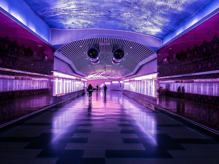 人们在紫光和蓝光的建筑中行走