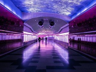 人们在紫光和蓝光的建筑中行走