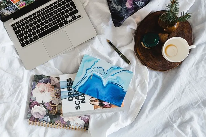 床上放满了枕头和带苹果小玩意的笔记本