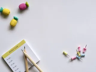 粉色、黄色、蓝色图钉和棕色铅笔