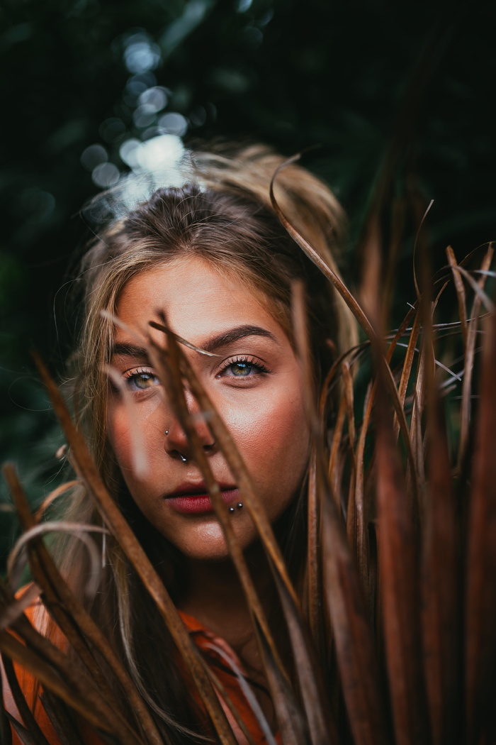 一个女人在干树叶后面的特写照片