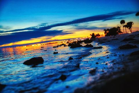 海滩，日落，黄昏，水上日落，城市灯光，海滩特写，夕阳余晖，天空