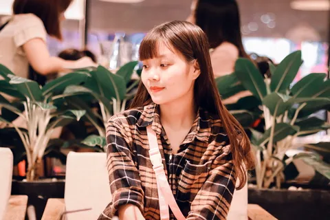 坐在沙发上穿着黑棕色格子运动衫的女人