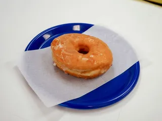 放在蓝色盘子上的上釉甜甜圈