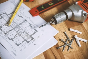 木背景上的特写钻孔工具和公寓平面图