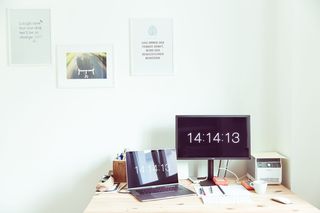 打开棕色木质表面笔记本电脑旁的平板电脑显示器