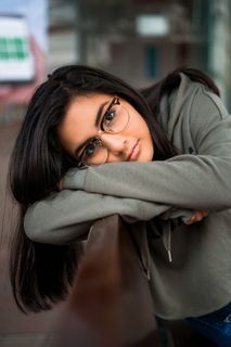 身穿灰色长袖衬衫的女子倚在船上