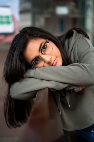 身穿灰色长袖衬衫的女子倚在船上