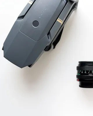 黑色变焦镜头旁的灰色DJI Mavic Pro无人机