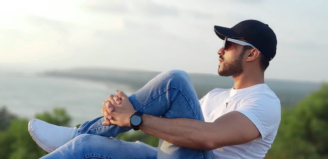 穿着白色圆领T恤的男子坐着的照片