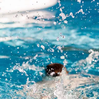 在游泳池上跳水的人