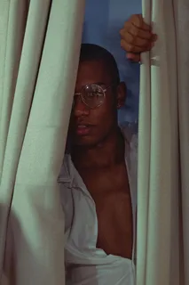 窗帘后穿白色上衣的男人