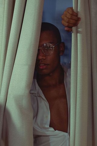 窗帘后穿白色上衣的男人