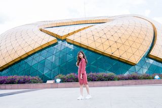 一名女子穿着粉红色长袖连衣裙的照片